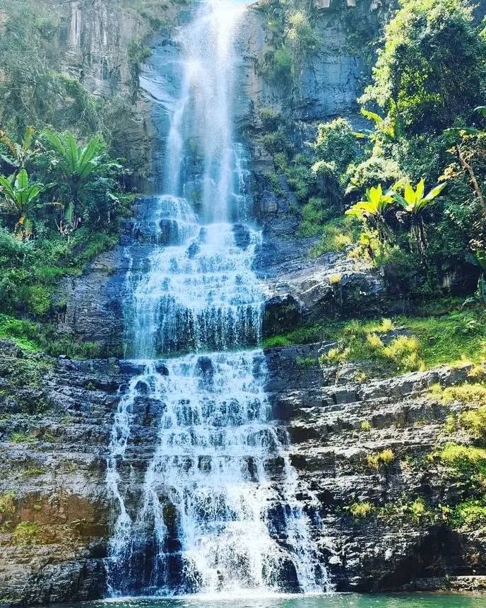 Person swimming beneath a rocky waterfall in Chimanimani