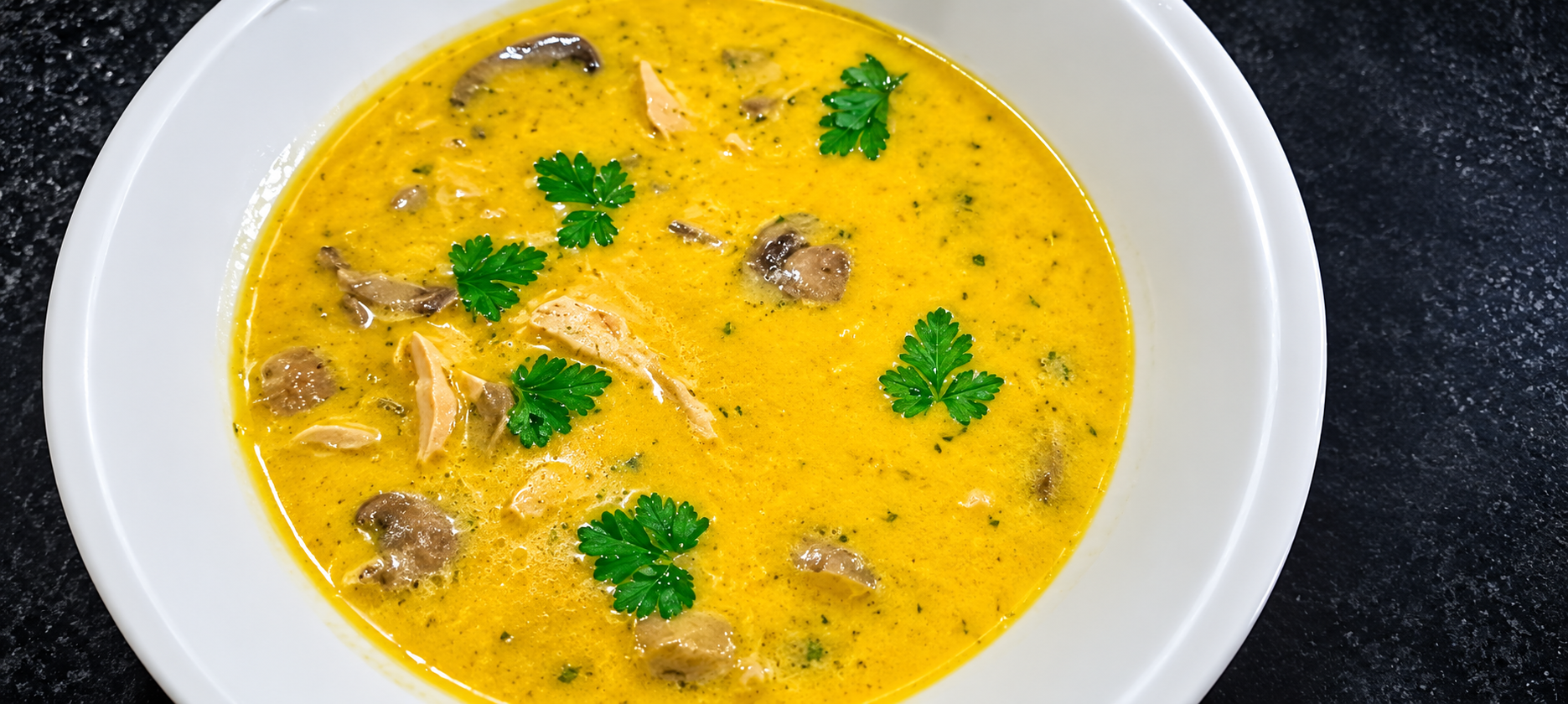 Creamy chicken and mushroom soup garnished with fresh herbs
